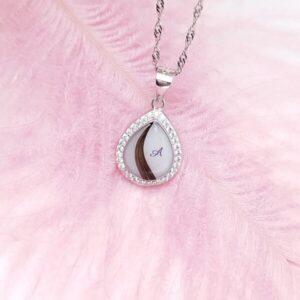 Collier Naema en résine de lait maternel blanc nacré sur chaîne, fond blanc