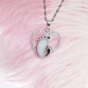 Collier Petit petons de lait en résine de lait maternel blanc nacré sur chaîne, fond blanc