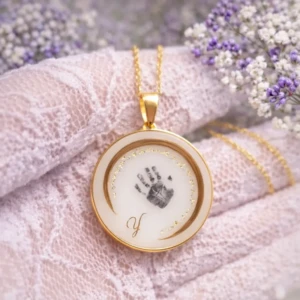 Médaillon croissant de lune en résine de lait maternel sur chaîne dorée, fond blanc