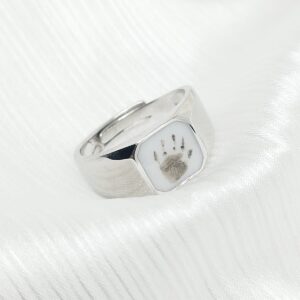 Bague Adam en résine lait maternel blanc, monture argentée sur fond blanc