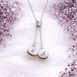 Collier Delicatesse en résine de lait maternel blanc nacré sur chaîne, fond blanc