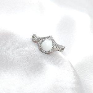 Bague Holia en résine lait maternel blanc, monture argentée sur fond blanc