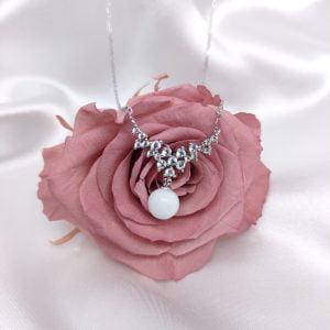 Collier Lumineuse en résine de lait maternel blanc nacré sur chaîne, fond blanc