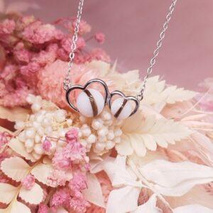 Collier Lait 2 coeurs en résine de lait maternel blanc nacré sur chaîne, fond blanc