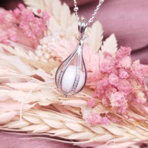 Collier Physalis l'amour en cage en résine de lait maternel blanc nacré sur chaîne, fond blanc