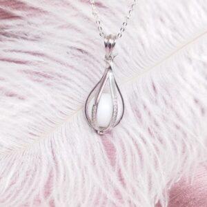 Collier Physalis l'amour en cage en résine de lait maternel blanc nacré sur chaîne, fond blanc