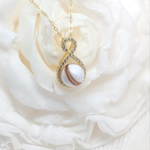 Collier Amour infini en résine de lait maternel blanc nacré sur chaîne, fond blanc