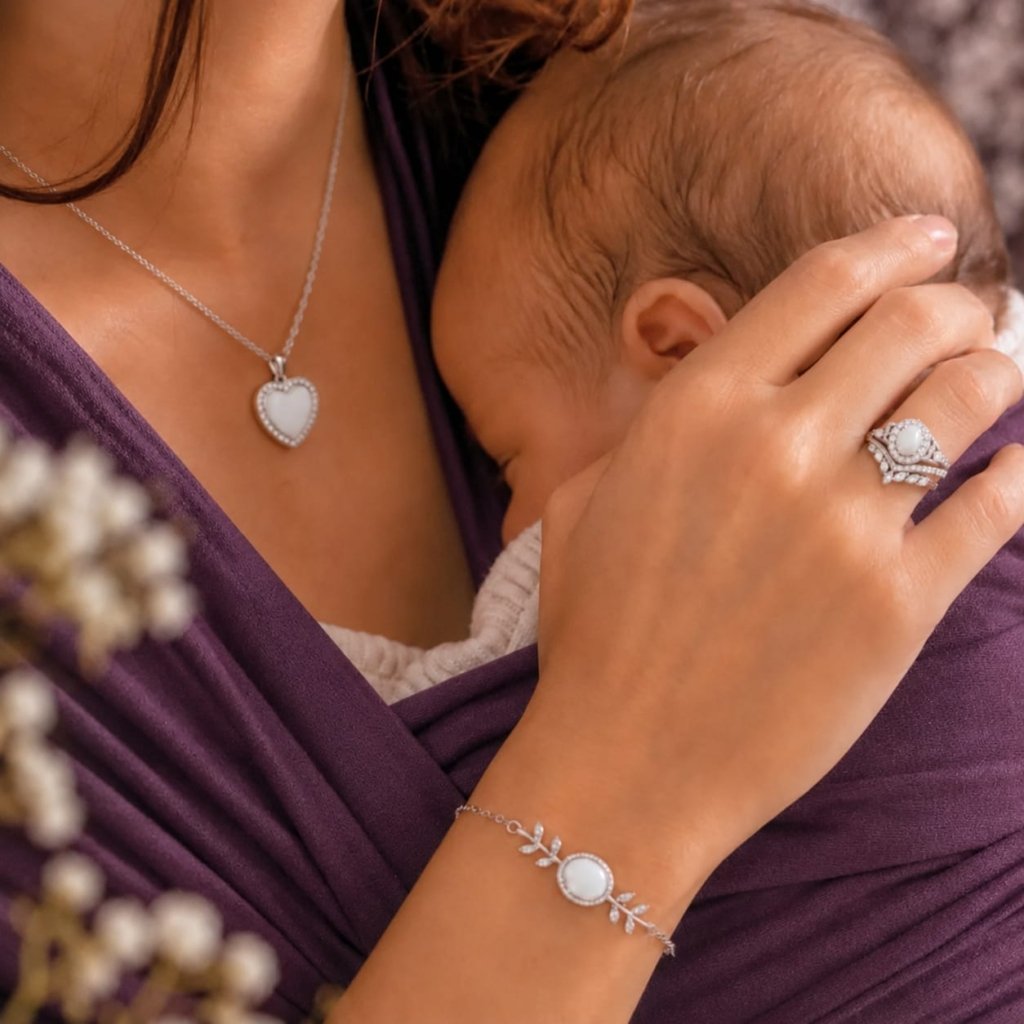 Maman portant son bebe, collier coeur, bague et bracelet au lait maternel